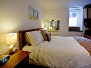 a bedroom with a bed and a table with a lamp at Devon Villa Garden Apartment in Torquay