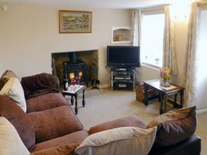 a living room with a couch and a fireplace at Thornhill in Whitchurch