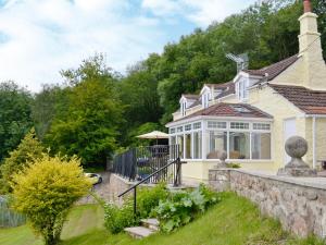 una casa con una pared de piedra y una valla en Thornhill, en Whitchurch