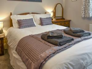 a bedroom with a large bed with towels on it at Lavender Cottage was Fellside in Melmerby