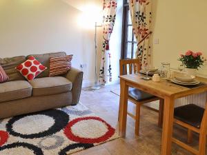 a living room with a couch and a table at The Stable in High Halstow