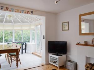 sala de estar con TV de pantalla plana y mesa en Coastal Hideout, en Wells-next-the-Sea