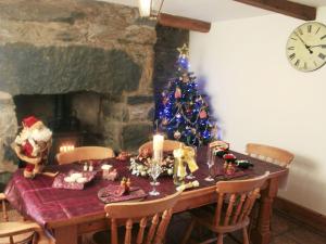 a dining table with a christmas tree in a room at Dalar Deg in Pentrefoelas