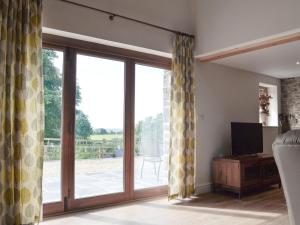 a living room with sliding glass doors leading to a patio at Bwthyn Y Bugail in Felindre