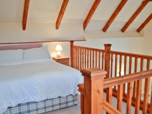 um quarto com uma cama e uma escada de madeira em Taw em Great Torrington
