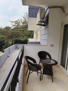 two chairs and a table on a balcony at The Himalayan Haven- Luxury 1 BHK Apartment in Rājpur