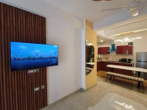 a living room with a flat screen tv on a wall at The Himalayan Haven- Luxury 1 BHK Apartment in Rājpur