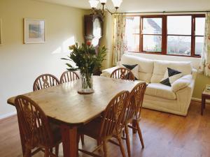 uma sala de estar com uma mesa e cadeiras e um sofá em Swallows Cottage em Tipton Saint John