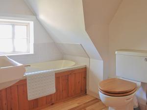 uma casa de banho com um WC, um lavatório e uma banheira em Burnt House Cottage em Barking