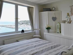 a bedroom with a bed with a view of the ocean at Seaside Stories in Brixham