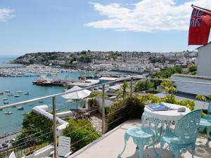 布里克瑟姆的住宿－Seaside Stories，阳台配有桌椅,享有海港的景致。