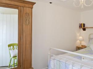 a bedroom with a bed and a mirror at Apple Cottage in Culmington
