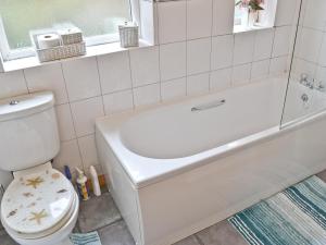 a bathroom with a white tub and a toilet at Mount Lea in Hinderwell