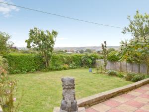 a garden with a stone bear statue in the yard at Mount Lea in Hinderwell