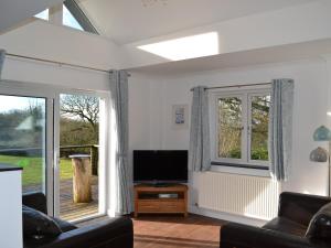 a living room with a tv and a window at Sunny Skies in St Austell