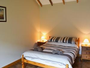 フランボローにあるPloughmans Cottageのベッドルーム1室(ベッド1台、ナイトスタンド2台、ランプ2つ付)