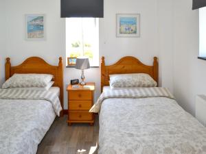 two beds sitting next to each other in a bedroom at Sunny Skies in St Austell