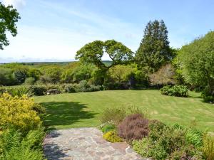 a garden with a green lawn and some bushes at Sunny Skies in St Austell
