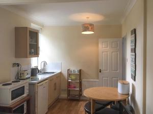 a small kitchen with a table and a small table with a table at Fawn Lea Apartment in Staindrop