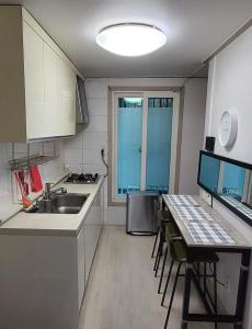 a kitchen with a sink and a table with chairs at On the main street of HBC in Seoul