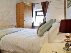 1 dormitorio con 1 cama con sábanas y almohadas blancas en Bron Elan, en Dolwyddelan