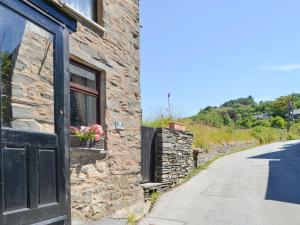 a stone building with a door and a window at Bron Elan in Dolwyddelan