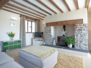 a living room with a couch and a fireplace at Little Nymett in North Tawton