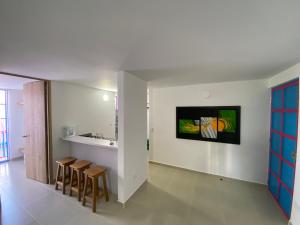 a room with a kitchen and some stools at Aparta Hotel Jardines de Guatape By Hope in Guatapé