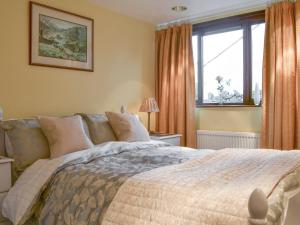 a bedroom with a large bed and a window at Harwood Dale Cottage in Kendal
