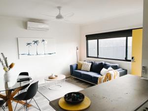 a living room with a couch and a table at Beachcomber Holiday Units in Lakes Entrance