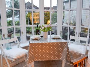 a dining room with a table and chairs and windows at The Studio in Cuckfield