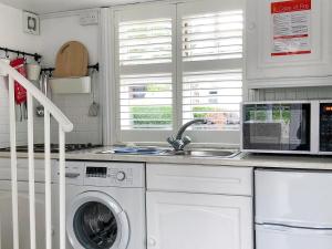 a kitchen with a washing machine and a sink at The Studio in Cuckfield