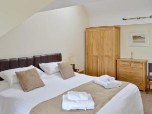 a bedroom with two white towels on a bed at Harbour View in Castletown