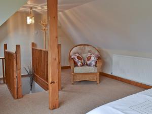 a bedroom with a wicker chair and a bed at Kiln Cottage in Rye