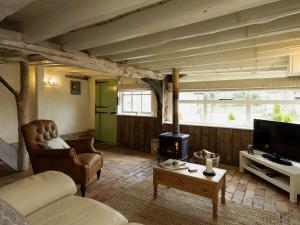 a living room with a couch and a fireplace at The Dairy in Heveningham