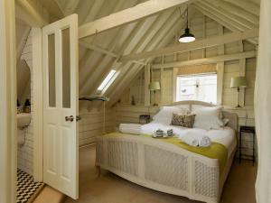 a bedroom with a white bed in a attic at The Dairy in Heveningham