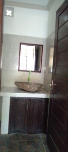 La salle de bains est pourvue d'un lavabo et d'une fenêtre. dans l'établissement Ping Pong homestay Gili Trawangan, à Gili Trawangan