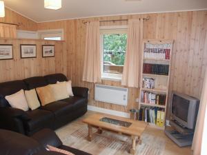 a living room with a couch and a tv at Amber Nook in Tirril