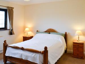 a bedroom with a large bed with two night stands at Canon Court Farm in Haydon