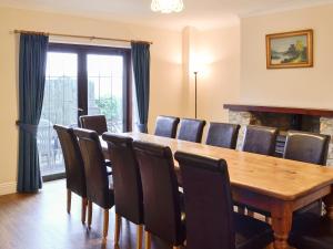 uma sala de jantar com uma mesa de madeira e cadeiras em Canon Court Farm em Haydon