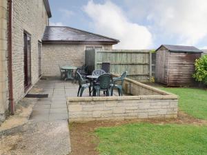 a patio with tables and chairs and a fence at Canon Court Farm in Haydon