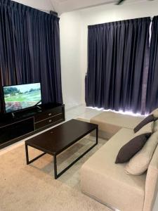 uma sala de estar com um sofá e uma televisão de ecrã plano em Hud-Hud Homestay 2 Gelang Patah em Gelang Patah