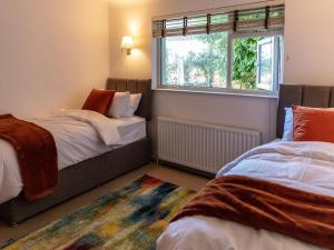 a bedroom with two beds and a window at Greenridge in Totland