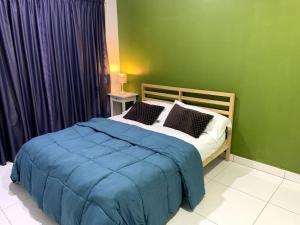 a bedroom with a bed with a blue blanket at Hud-Hud Homestay 2 Gelang Patah in Gelang Patah