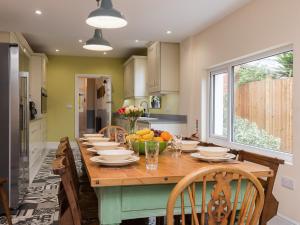 a kitchen with a long wooden table with chairs at The Beach House in Weston-super-Mare