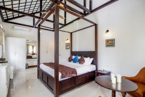 a bedroom with a canopy bed and a table at Villa Beleza Infinita in Mapusa