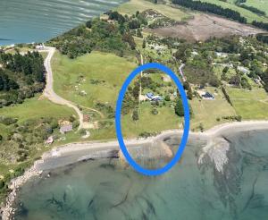 uma vista aérea de uma ilha com um círculo azul em Summerspring Beachfront Accommodation em Takaka