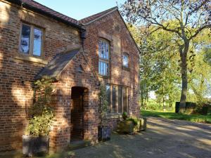 a brick house with a tree in front of it at The Ashes in Middleton One Row