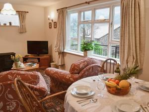 a living room with a table and chairs and a window at Fell View in Kentmere