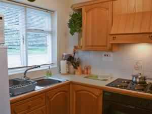 a kitchen with wooden cabinets and a sink and a window at Fell View in Kentmere